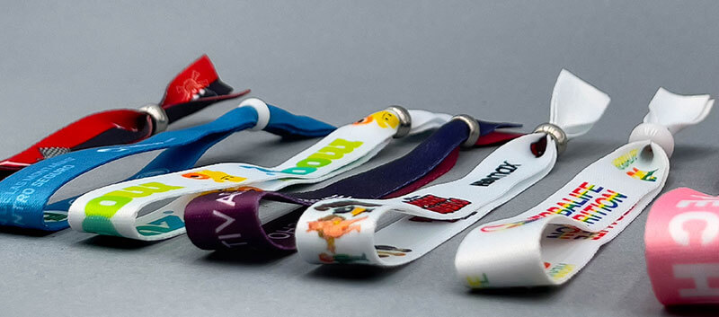 Pulseras publicitarias de tela con diferentes acabados, colores y cierres